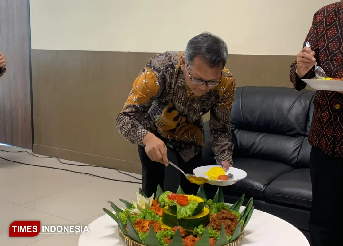 Dekan Fakultas Vokasi UB saat melakukan prosesi pemotongan tumpeng. (FOTO: Miranda/TIMES Indonesia)