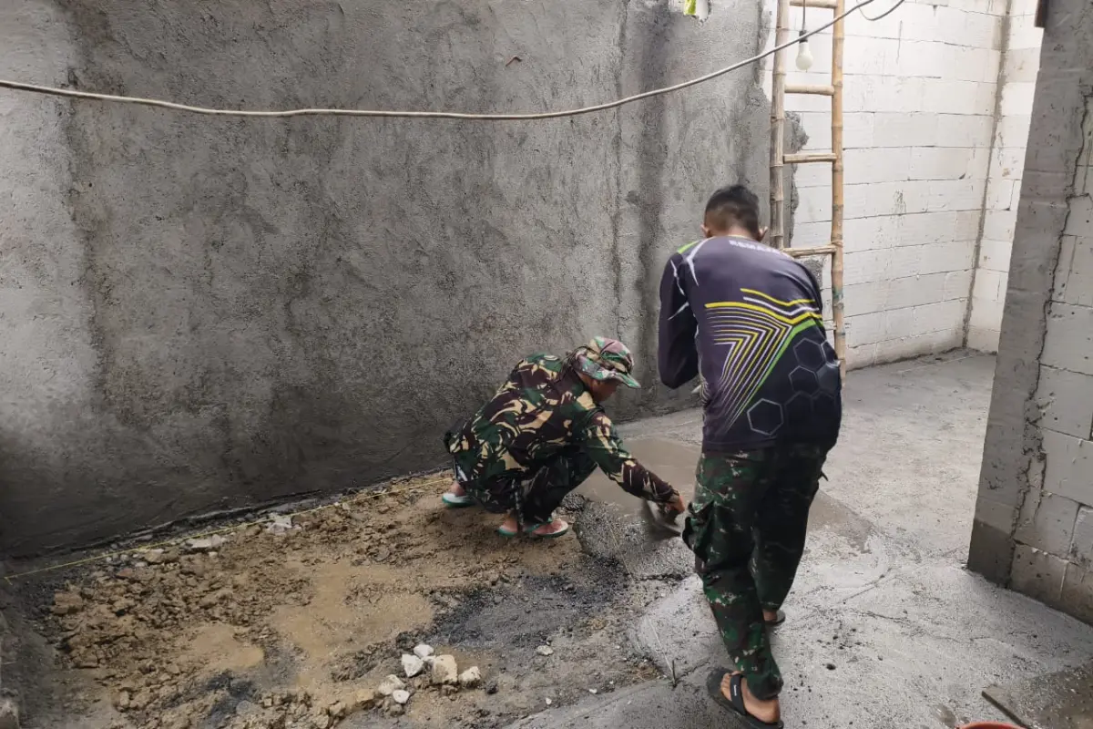 Gotong Royong Satgas TMMD 128 Gresik dan Warga Ratakan Lantai Rumah Ibu Eka
